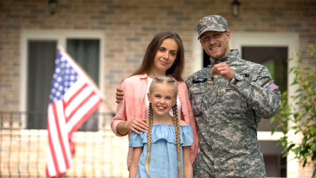 US military veteran with family in front of new home